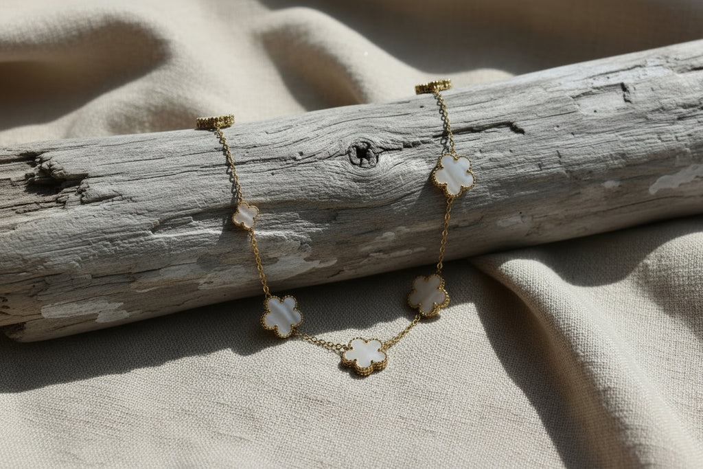 collier acier doré et fleurs en blanc nacré